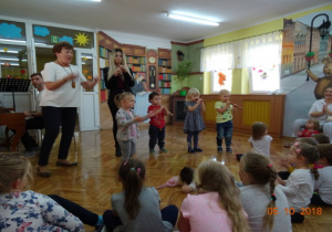 4 dzieci gra na fletach na scenie. Pozostałe dzieci oglądają ich występ.